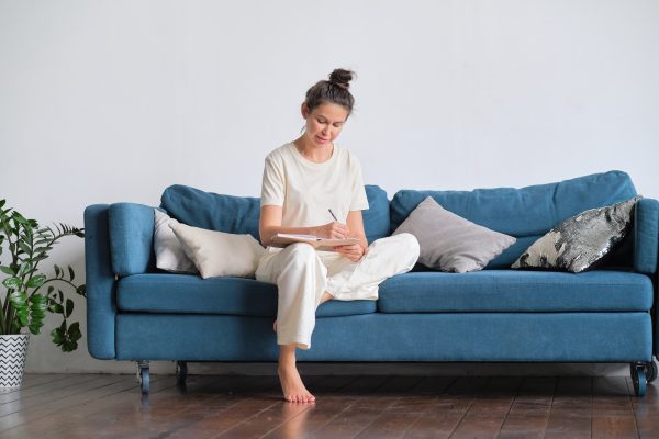 Happy woman dreaming at home. woman writes down her plans in a diary.